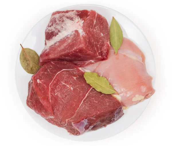 大きな片の骨のない豚肉と後ろ足の牛肉 白い背景に白い皿の上にベイリーフと鶏の胸肉 トップビュー — ストック写真