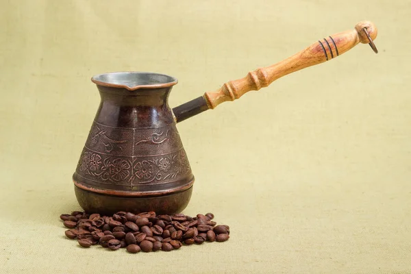 木製のハンドルと繊維表面にローストコーヒー豆を散在ヴィンテージ銅コーヒーポット — ストック写真