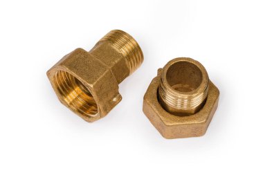 Beyaz arka planda uygun fındıkla boruları birbirine bağlayan iki pirinç işlemeli boru.