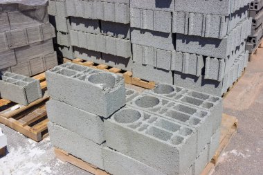 İnşaat beton birimleri, ayrıca beton bloklar olarak adlandırılan açık hava deposundaki paletlerin üzerine istiflenmiş.