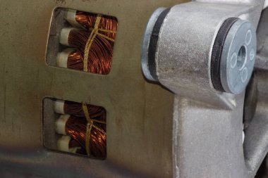 Kapağında havalandırma delikleri olan elektrikli bir motor parçası. Bu parçanın içinden sarkaçlar ve şok emici motor ön planda görülebilir. Seçici odak noktasında yakın plan.