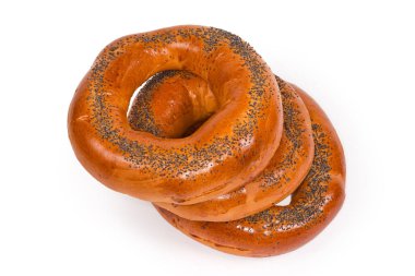 Beyaz arka planda pişmeden önce haşlanmış haşhaş tohumları serpiştirilmiş geleneksel Doğu Avrupa halka şeklinde ekmek ruloları yığını