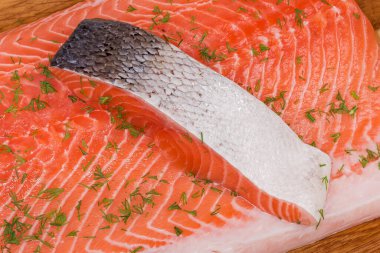 Dilimlenmemiş çiğ somon derisi, somon filetosu üzerine serpiştirilmiş deriden yapılma, yakın plan.