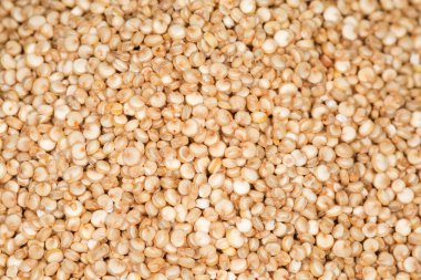 Yığının üzerinde çiğ beyaz kinoa çekirdekleri, üst görünüm seçici odak, arkaplan