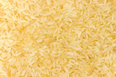 Orta pişmiş çiğ pirinç eşit olarak serpilmiş, üst görünüm yakın plan, arka plan