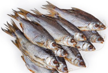 Heap of salted and air-dried roach fish on string on a white background, fragment top view close-up