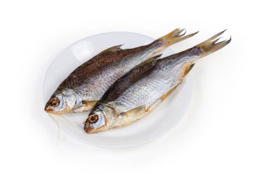 Two salted and air-dried roach fish on white dish on a white background