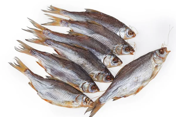 Several salted and air-dried roach fish on string on a white background, top view