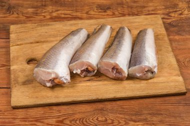 Kafası ve kuyruğu olmayan, Arjantin 'in çözülmüş çiğ leşleri, eski bir kırsal masada ahşap kesme tahtasındaki balık pullarından temizlenmiş.