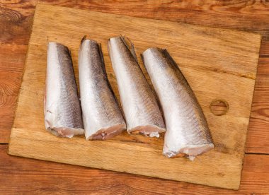 Kafası ve kuyruğu olmayan, Arjantin 'in çözülmüş çiğ leşleri eski bir kırsal masada, ahşap kesme tahtasındaki balık pullarından temizlenmiştir.