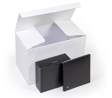 Büyük, beyaz, dikdörtgen karton kutu ve aksesuarlı iki küçük siyah düz kutu. 