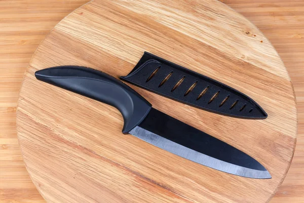 Ceramic kitchen knife with removed blade protector on cutting board