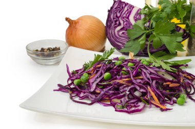Beyaz arka planda çeşitli malzemelere karşı taze kırmızı lahana ve diğer sebzeli salata.