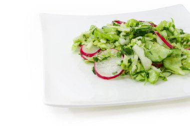 Dilimlenmiş taze lahana, salatalık, kırmızı turp ve doğranmış yeşil soğandan yapılmış sebze bahar salatası, beyaz arka planda küçük bir parça.