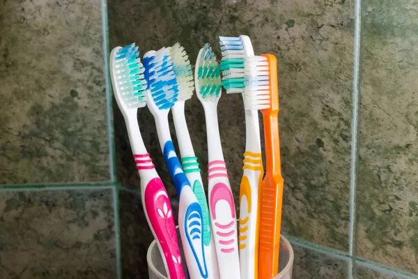 Several Different Toothbrushes Stand Background Wall Bathroom Covered Green Tile — Stock Photo, Image