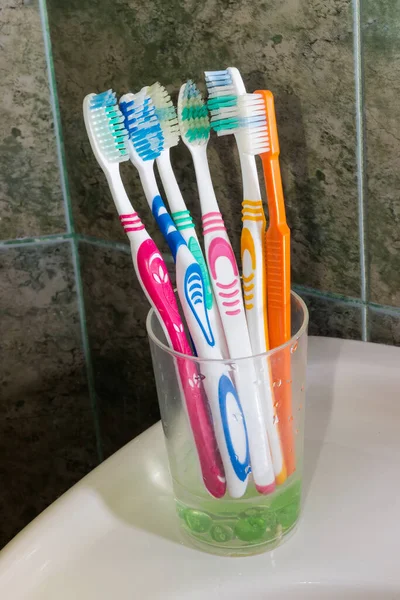 Different Toothbrushes Stand Background Wall Bathroom Covered Green Tile — Stock Photo, Image
