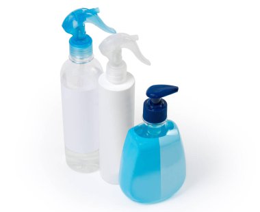 İki farklı antiseptik şişesi, el yapımı spreyler ve antibakteriyel içerikli sıvı sabun, beyaz bir arka planda şeker kutusuyla birlikte.