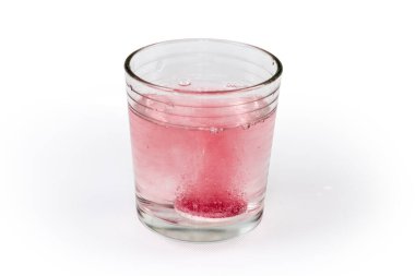 Çözünmenin başlangıcında, açık yüzey üzerinde duran ve su bardağına atılan farmasötik ilaç tableti.