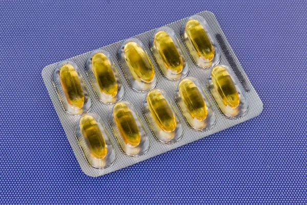 Arzneimittel Form Von Gelben Durchscheinenden Gelatinekapseln Der Blisterverpackung Auf Blauer — Stockfoto