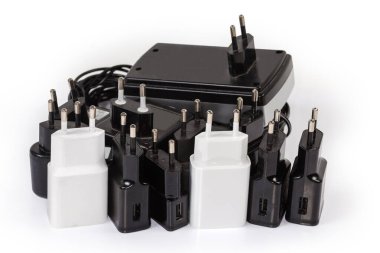 Taşınabilir elektronik aksesuarları şarj etmek için AC Europlugs ile farklı adaptörler ve şarj cihazları, beyaz arka plan üzerine seçici odaklı yakın plan
