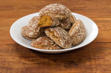 Zencefilli ekmekler, eski kırsal masada beyaz tabakta krema şekeri ile kaplanmış, yakın plan.