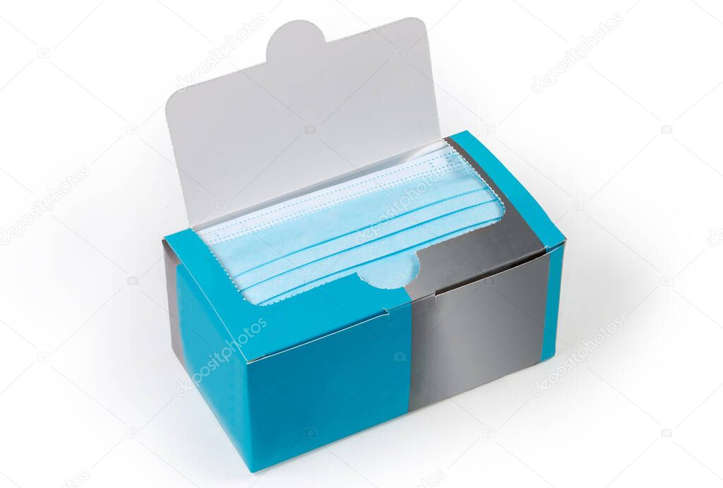 Open packaging in the form of a cardboard box of the light blue disposable medical face masks on a white background