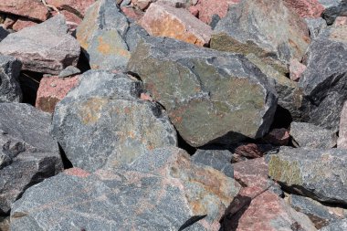 Taşlardan yapılmış gri ve kırmızı granit parçaları. Yazın farklı boyutlarda.