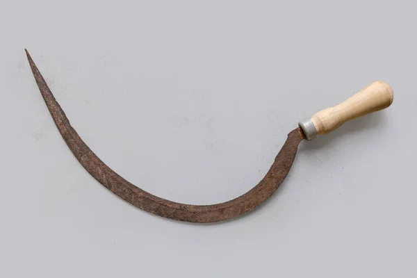 旧生锈的镰刀 有细锯齿状半圆形刀片和木制柄 表面浅色 顶部视图 — 图库照片