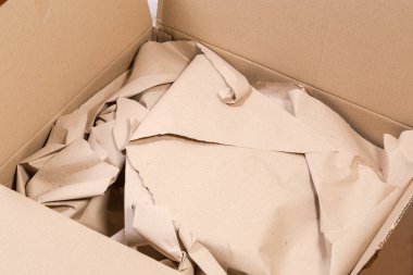 Kraft kıvrımlı fiberboard ile yapılmış dikdörtgen ambalaj kutusunu aç içinde hafifçe buruşmuş ambalaj kağıdı, parçanın üst görünümü
