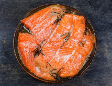 Gökkuşağı fileto 'sunun pişmiş parçaları karanlık bir yüzey üzerinde cam fırın kabında, üst manzara