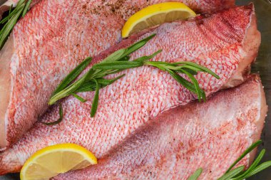 Başsız çiğ kırmızı balık leşleri, okyanus levreği olarak da bilinir, pişirmek için baharatlarla hazırlanmış, yakın çekim.