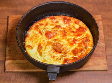 Pişmiş yumurtalar ahşap tezgahın üstünde, kırsal tavada pişmiş.