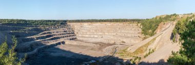 Ormanlar arasında gri granitin çıkarılması için çalışan maden ocakları, çıkıntıları ve iç döküntüleri olan taş ocakları, geniş panoramik manzara.