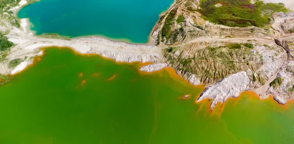 放棄されたイルミナイト採石場 空中パノラマビューのサイト上の色の湖と古い廃棄物岩のダンプ — ストック写真