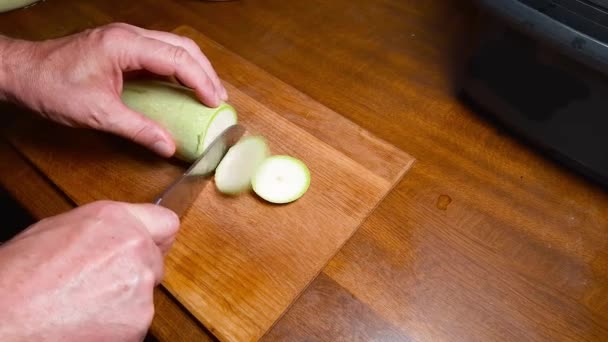 Skär Runda Skivor Den Färska Ljusgröna Grönsaksmärgen Träskärbräda Ett Köksbord — Stockvideo