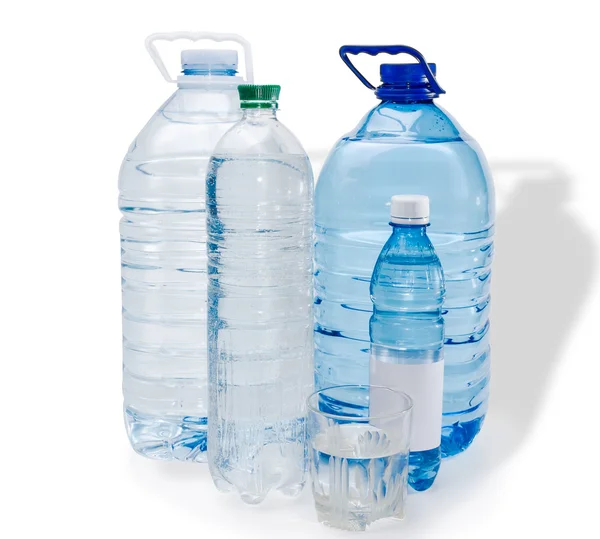 Flera flaskor och fullt glas vatten — Stockfoto