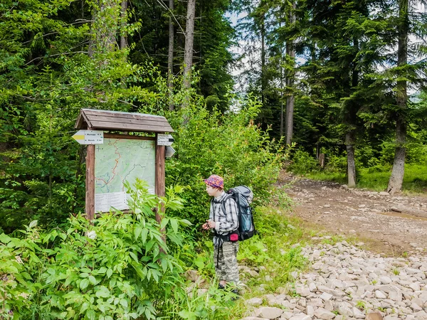 Giovane turista vicino schema percorsi di montagna — Foto Stock