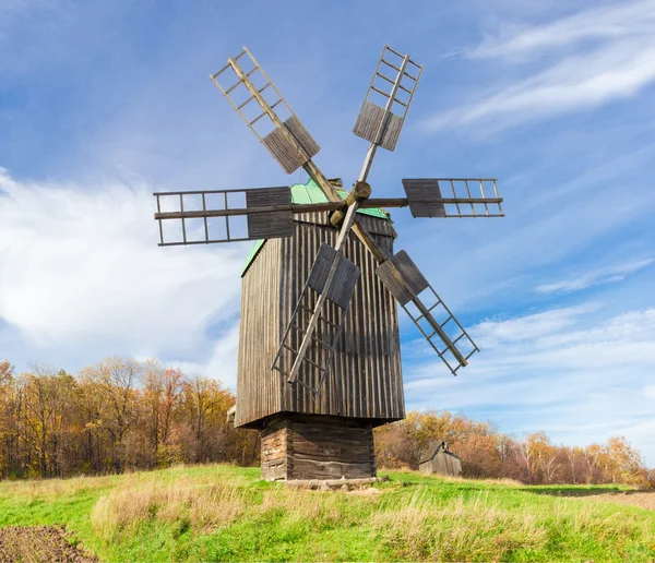 Starý větrný mlýn na pozadí lesa a obloha — Stock fotografie