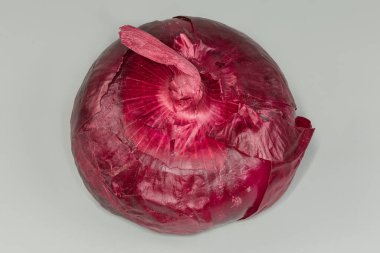 Gri arkaplanda kırmızı tatlı soğanın tek düz ampulü.