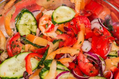 Paslanmaz çelik mutfak kâsesinde taze sebze ve yeşilliklerden yapılmış ince dilimlenmiş salata, seçici odak noktası olan parça.