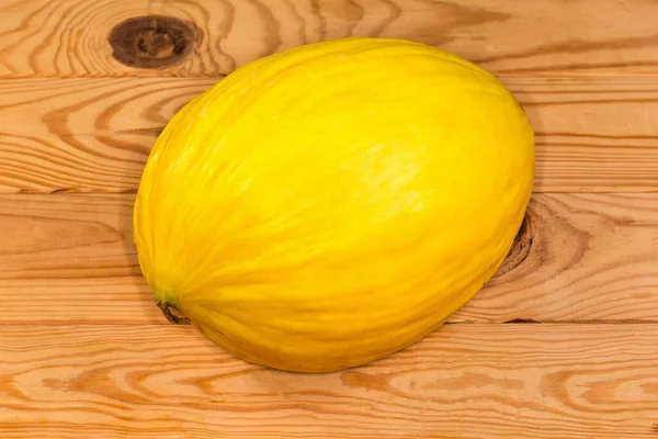 Taze kavun, ahşap bir kırsal masa üzerinde parlak sarı bir cilt.