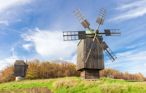 Starý větrný mlýn na pozadí lesa a obloha — Stock fotografie