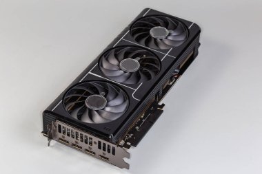 Masaüstü bilgisayarlarında kullanılan grafiksel kart, çift parantez, ısı giderici ve gri arka planda üç vantilatör, seçici odak noktasında yakın plan