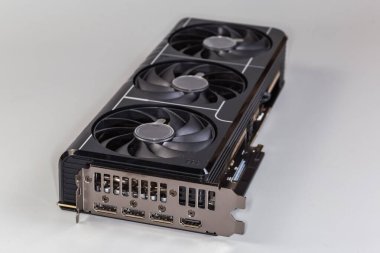 Masaüstü bilgisayarlarında kullanılan grafiksel kart, çift parantez, ısı giderici ve gri arka planda üç vantilatör, seçici odak noktasında yakın plan