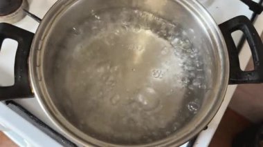 Ham donmuş kral karides kuyruklarını kaynar suya yüklüyorlar.