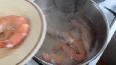 Pişmiş kral karidesini kaynar sudan çıkarıyorum.