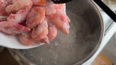 Donmuş karidesleri kaynar suya yüklüyorlar.