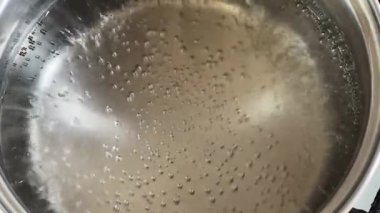 Su paslanmaz çelik tencerede kaynamaya başlar.