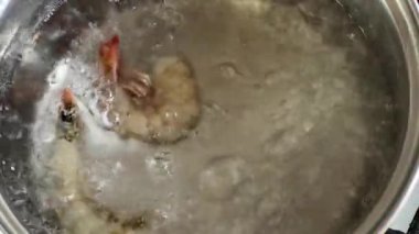 Donmuş karides kuyruklarını kaynar suya yüklüyorum.