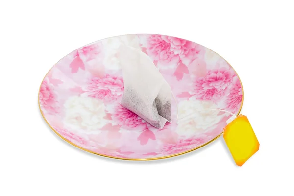 One tea bag on a pink saucer — Stock Photo, Image